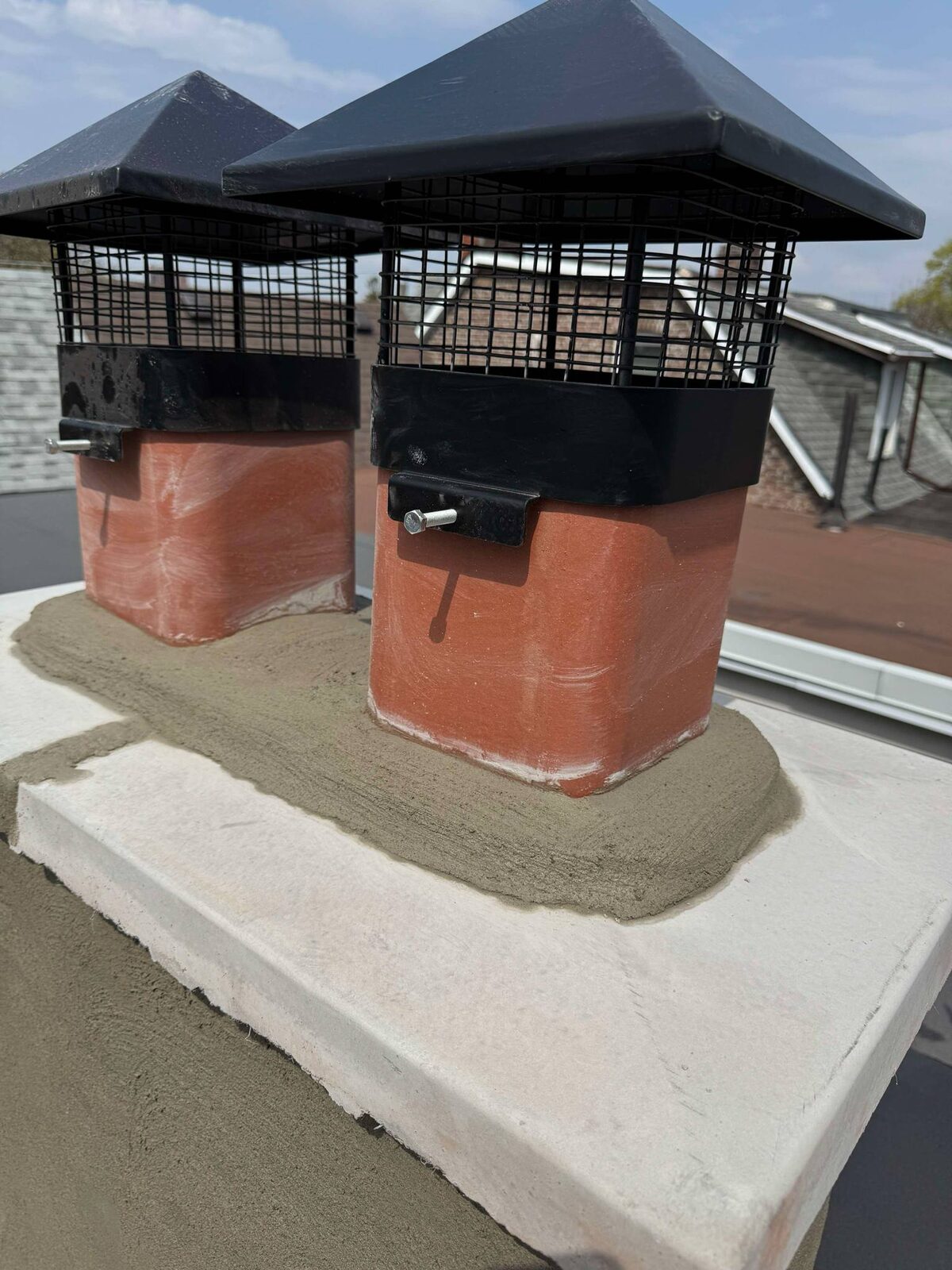 New chimney crown with clay pots and spark-arrestor caps