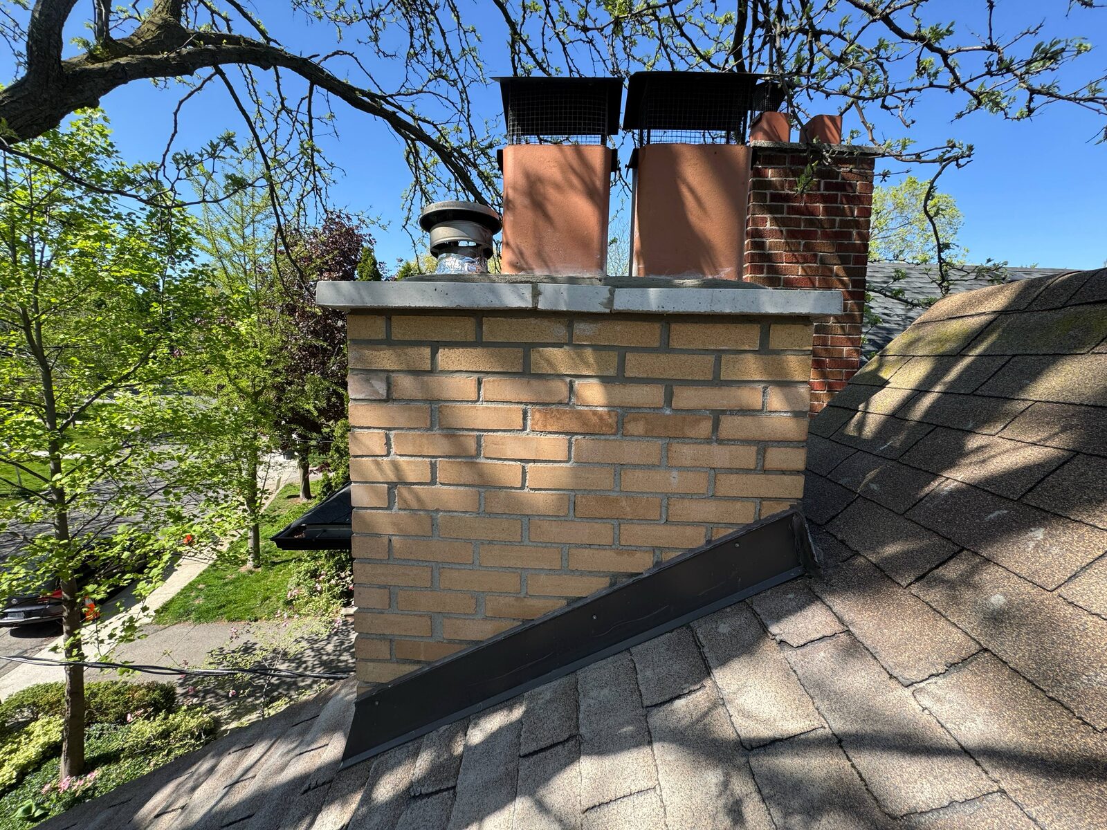 Completed chimney rebuild in buff brick with new crown, liners and caps, Toronto