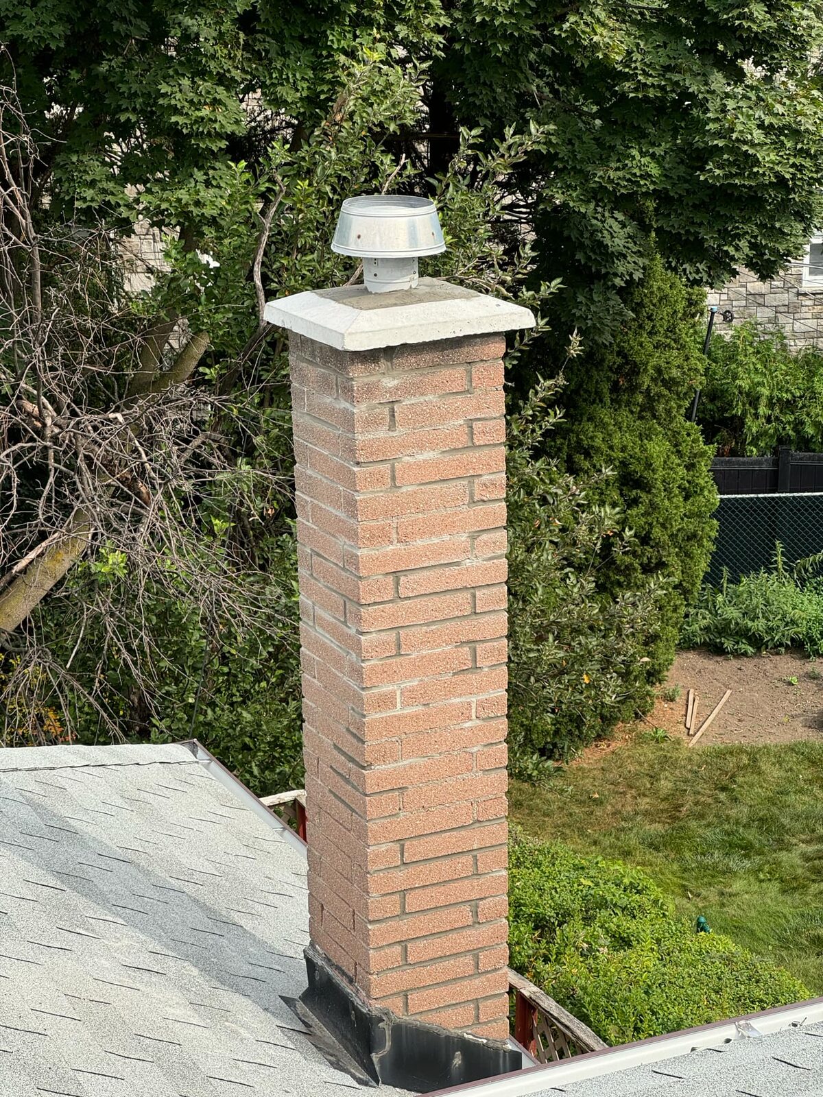 Rebuilt chimney with twin capped flues seen from the roof