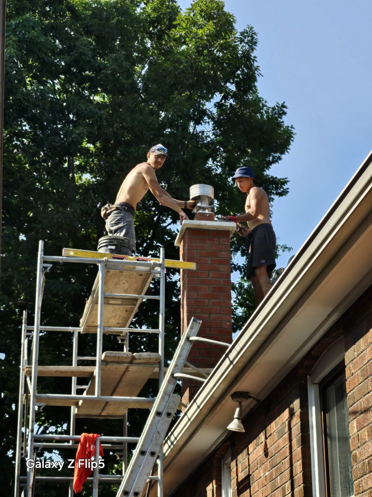 Krolicki crew rebuilding a chimney from scaffolding