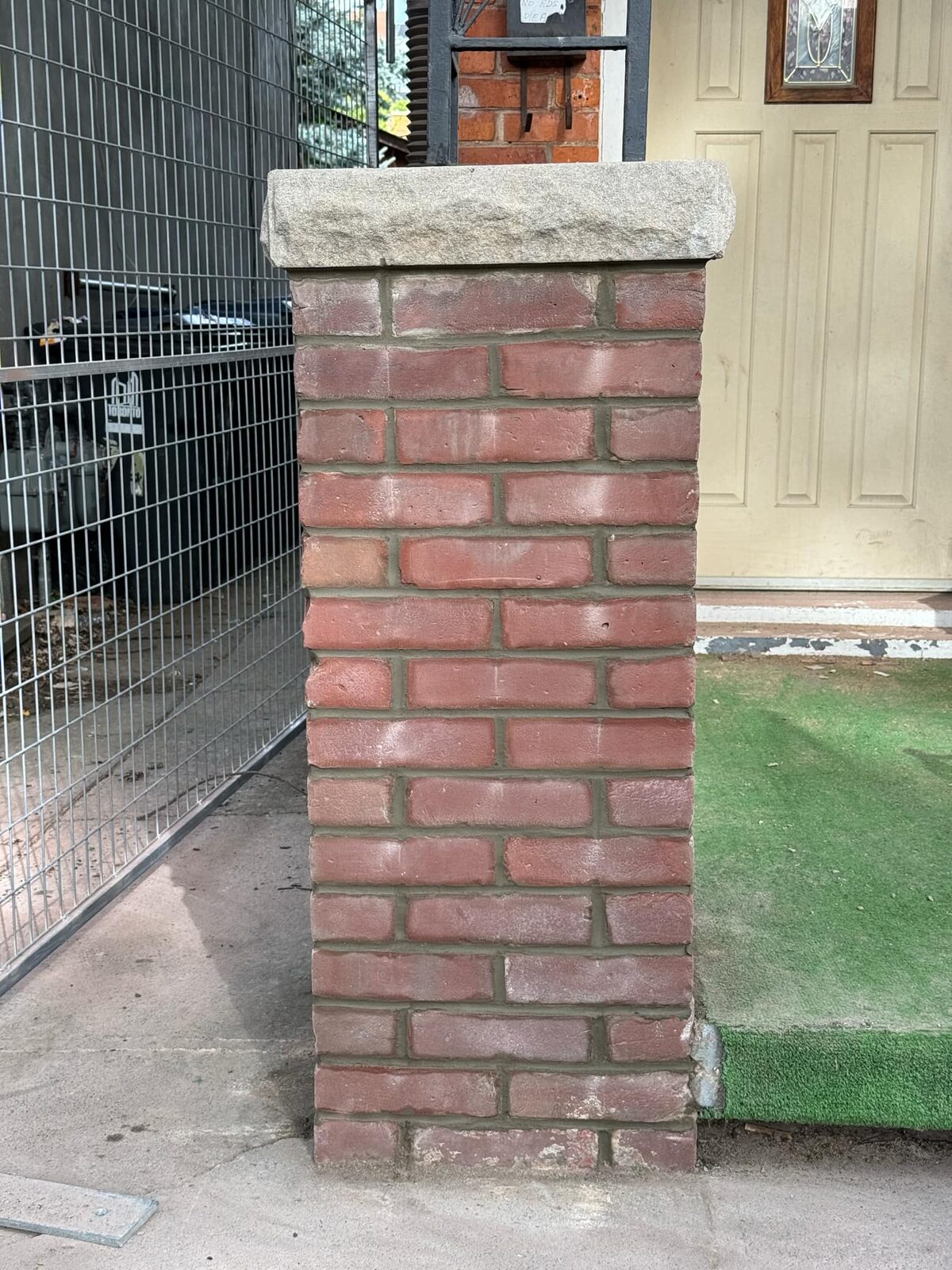 Rebuilt brick pillar with stone cap